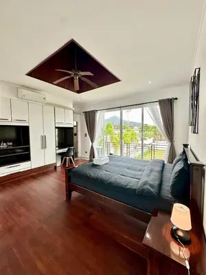 a bedroom with a large bed with a ceiling fan at The White House Kamala II in Kamala Beach