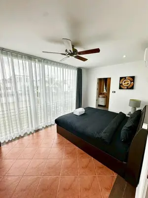 a bedroom with a bed and a ceiling fan at The White House Kamala II in Kamala Beach