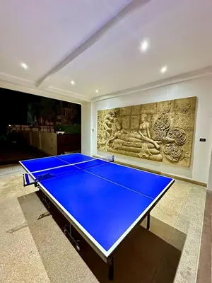 a ping pong table in a room with a painting at The White House Kamala II in Kamala Beach