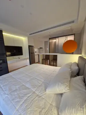 a large white bed in a room with a kitchen at Kora Beach Resort Phuket in Bang Tao Beach