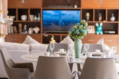 a dining room with a table with a vase of flowers at Tropical Pool Villa Thai-modern Villa with an OFFICE in Phuket Town