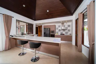 a kitchen with a large island with two bar stools at Tropical Pool Villa Thai-modern Villa with an OFFICE in Phuket Town