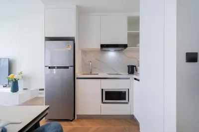 a kitchen with white cabinets and a refrigerator at The Sunshine Beach Resort 1-bedroom with a great view in Layan Beach