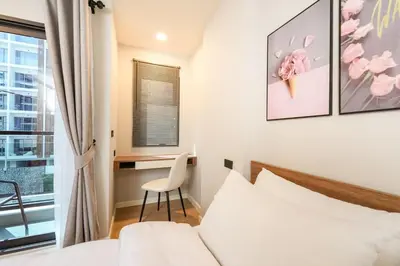 a bedroom with a bed and a desk and a window at New condo near the sea, Laguna, Choeng Thale 324 in Ban Thalat Choeng Thale