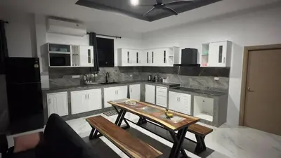 a kitchen with white cabinets and a wooden table at NEW! Welcome ! Villa - 3 bedroom 3 Baths - Ao Nang area in Ban Khao Klom