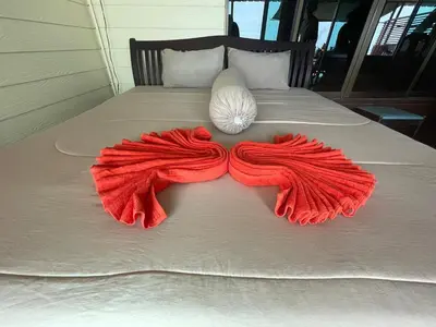 a red blanket on a bed with a shell on it at Fisherman's house on stilts Phuket Old Town in Ban Tha Khreng