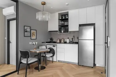 a kitchen with a table and chairs and a refrigerator at The Title Legendary Elegant Suite Bangtao in Ban Thalat Choeng Thale