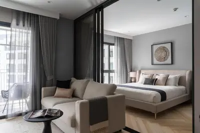 a bedroom with a bed and a couch at The Title Legendary Elegant Suite Bangtao in Ban Thalat Choeng Thale