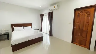 a bedroom with a bed and a wooden door at The Nap House Phuket Town in Phuket Town
