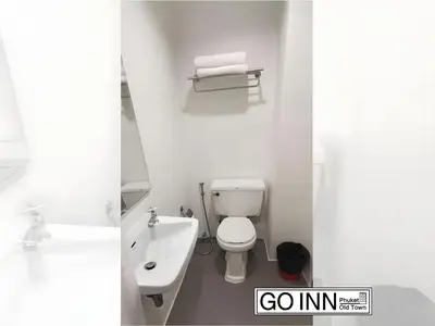 a white bathroom with a toilet and a sink at XX GO INN Phuket Old Town โก อินน์ ภูเก็ต ย่านเมืองเก่า in Phuket Town