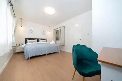 a bedroom with a bed and a green chair at 3BR pool at Bangla Patong reach beach in 5m walk in Patong Beach