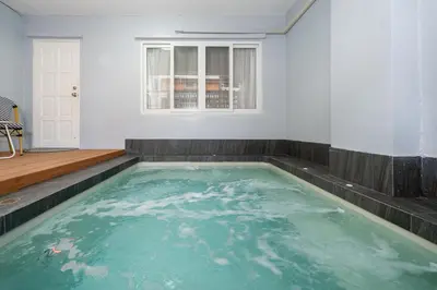 a swimming pool in a white room with a window at 3BR pool at Bangla Patong reach beach in 5m walk in Patong Beach