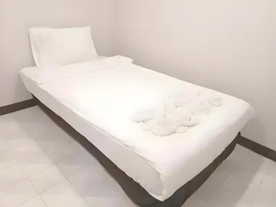 a white bed with white dishes on it at XX Mitr Inn - ภูเก็ต เมืองเก่า Phuket Old Town 2 in Phuket Town