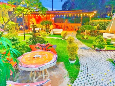 a painting of a garden with a bench in the grass at Suki Palm in Ban Bang Chak