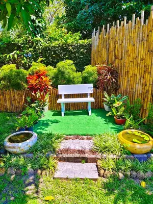 a bench sitting in the middle of a garden at Suki Palm in Ban Bang Chak