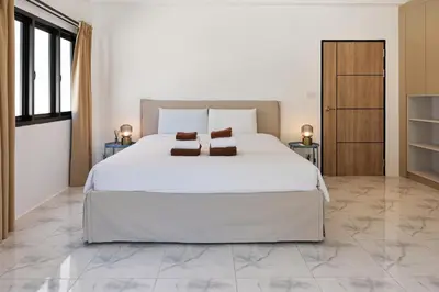 a bedroom with a large white bed and two tables at Modern Villa 4-BR, Breeze - 10 min walk to NaiYang beach in Nai Yang Beach