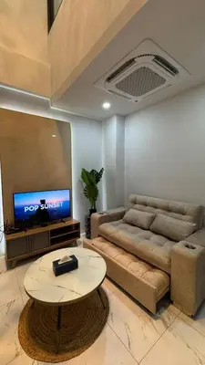 a living room with a couch and a table and a tv at Bang Jo Garden Home in Koh Lone