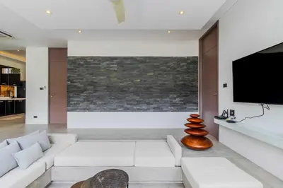 a living room with a white couch and a flat screen tv at V259 Great for Relaxing with Pool & Full Amenities in Thalang