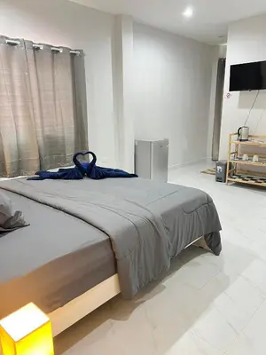 a bedroom with a large bed with a blue ribbon on it at Samakki Residence - Modern Rooms, Quiet Area, Near the Beach in Rawai Beach