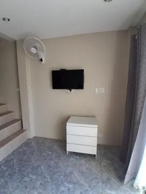 a living room with a tv and a white cabinet at Samakki Residence - Modern Rooms, Quiet Area, Near the Beach in Rawai Beach
