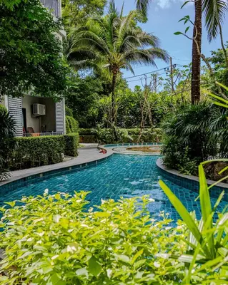 a swimming pool in the middle of a yard with trees at Cozy studio Pool View near of NaiYang beach in Nai Yang Beach