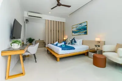 a bedroom with a bed and a desk and a couch at Villa Mimosa 4 - Luxury 4BR Private Pool - Rawai in Kata Beach