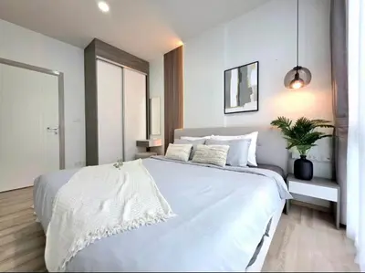 a bedroom with a large white bed and a potted plant at The Modern central Phuket base condo by luxStays in Ban Rangeng