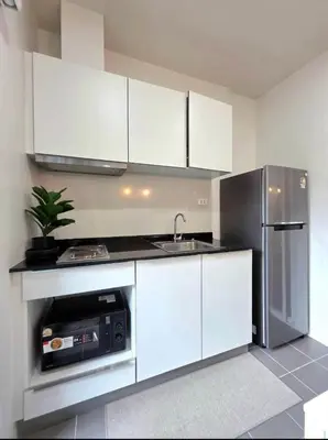 a kitchen with white cabinets and a stainless steel refrigerator at The Modern central Phuket base condo by luxStays in Ban Rangeng
