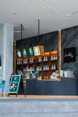 a person standing at a counter in a coffee shop at Cozy 1Bdr Apartment in La Vita Rawai Nai Harn in Rawai Beach