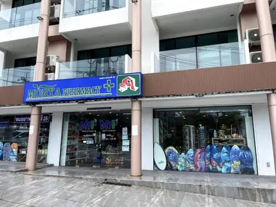 a store with a blue sign in front of a building at Modern condo with full sea view, 4 min walk to Kamala beach in Kamala Beach