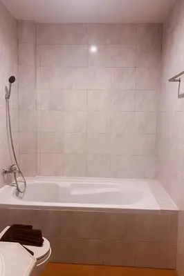 a bathroom with a bath tub and a toilet at Nova Patong in Patong Beach