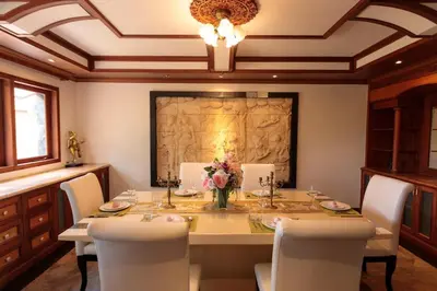 a dining room with a table and white chairs at Classic Cozy Thai Villa BIG pool Party OK in Patong Beach