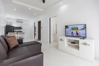 a living room with a couch and a flat screen tv at Ali Cozy Houses in Ban Thalat Choeng Thale
