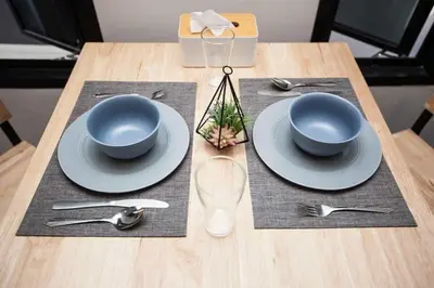 a table with two blue bowls and plates on it at comfortable BAMBOO houses in Ban Thalat Choeng Thale