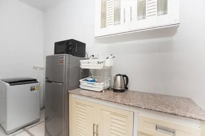 a kitchen with a refrigerator and a counter top at cozy Best house with garden near Bang Tao beach in Ban Thalat Choeng Thale