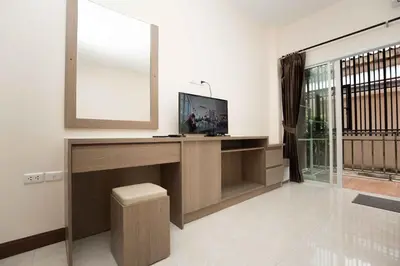 a living room with a television and a mirror at RICH house in Ban Thalat Choeng Thale