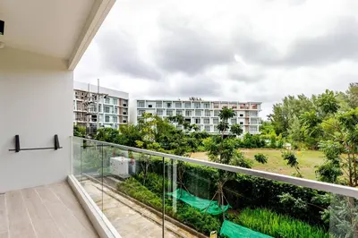 a balcony with a view of a building at Laya Resort Garden Escape- Tropical Serenity Suite in Layan Beach