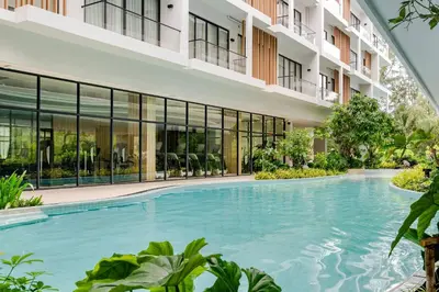 an external view of a building with a large swimming pool at Laya Resort Garden Escape- Tropical Serenity Suite in Layan Beach