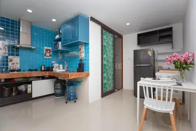a kitchen with blue tile walls and a counter at Waterfall House, 800 m to the Bang Tao beach in Ban Thalat Choeng Thale