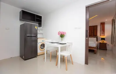 a kitchen with a white table and a refrigerator at Waterfall House, 800 m to the Bang Tao beach in Ban Thalat Choeng Thale