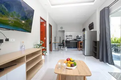 a kitchen and living room with a bowl of fruit on a table at GA-GA-GA A cozy house in a quiet location on Bang Tao Beach in Ban Thalat Choeng Thale