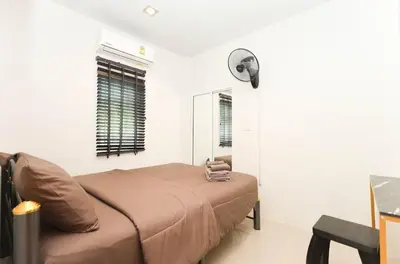 a bedroom with a bed and a fan at BAN House, Bang Tao beach in Ban Thalat Choeng Thale