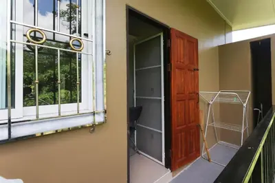 a room with a window and a wooden door at BAN House, Bang Tao beach in Ban Thalat Choeng Thale
