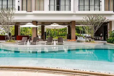 a hotel swimming pool with chairs and umbrellas at Laya Resort -Tropical Studio in Layan Beach