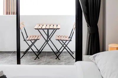 two chairs sitting next to a mirror in a bedroom at Stay White Orchid in Krabi town