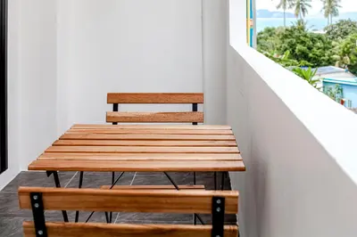 a wooden table and two chairs on a balcony at Stay White Orchid in Krabi town