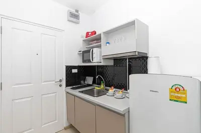 a kitchen with a white refrigerator and a sink at Zcape 1 bedroom apartment in Ban Thalat Choeng Thale