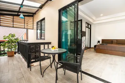 a living room with a table and chairs and a bed at Cat house, 5 min to the beach in Ban Thalat Choeng Thale