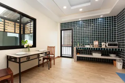 a dining room with a table and a kitchen at Cat house, 5 min to the beach in Ban Thalat Choeng Thale