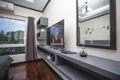 a room with a desk with a television and a window at Beautiful apartment in Ban Thalat Choeng Thale
